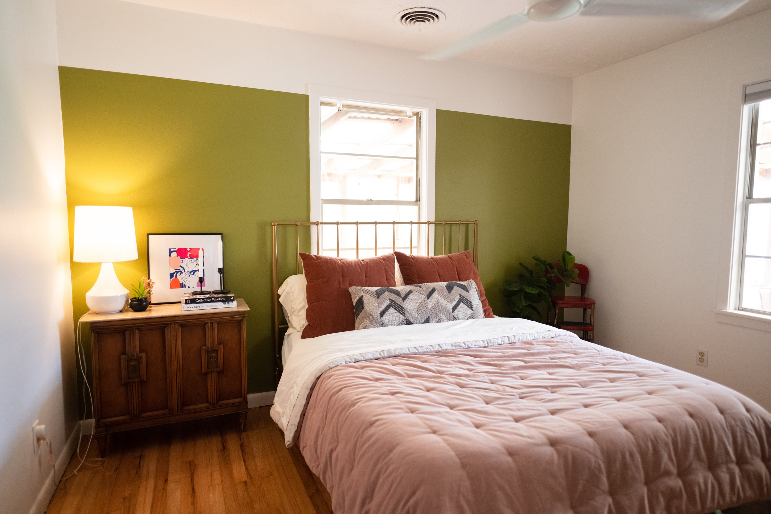 A bedroom with a chartreuse paint color accent wall